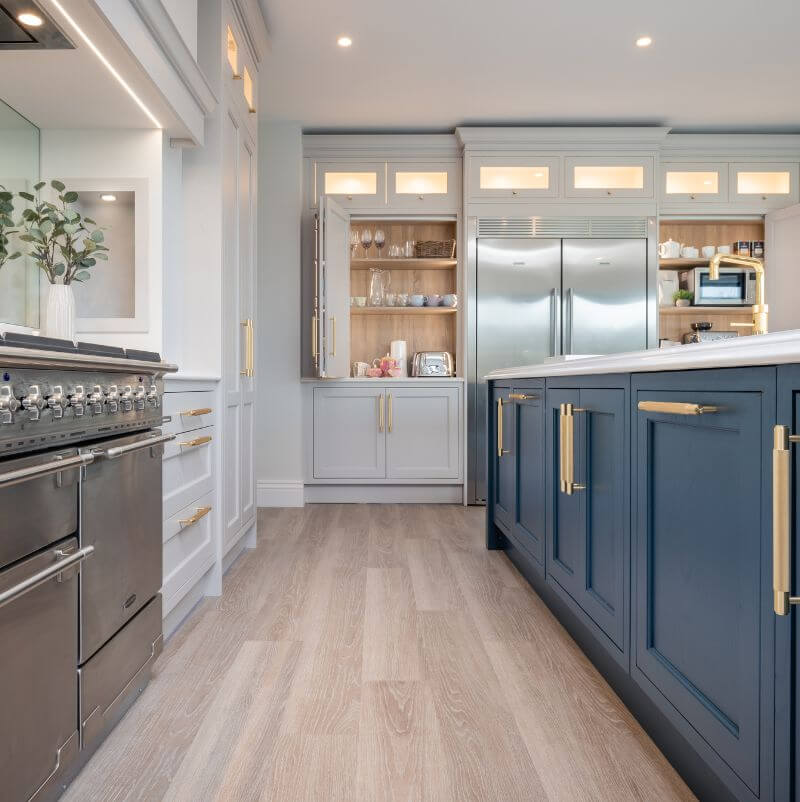 buster and punch cross brass handles on navy and off white cabinetry kitchen image