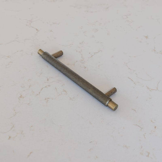 Antique Brass kitchen Cabinet Handle on flecked counter top