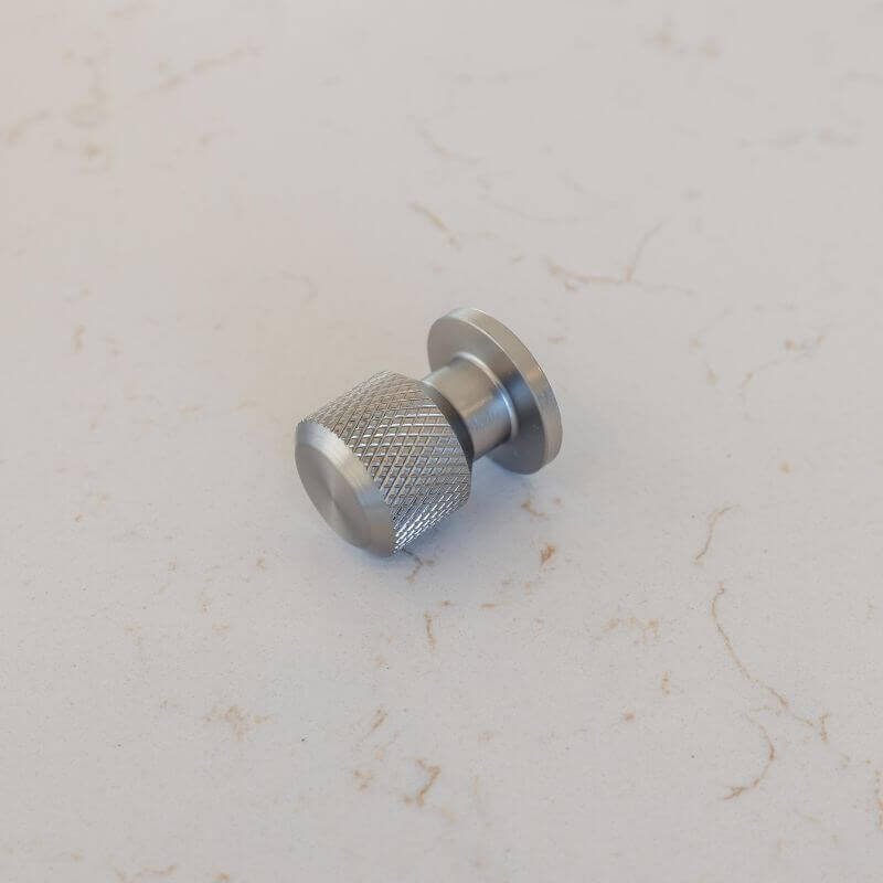 Steel Finish round knob on flecked counter top background